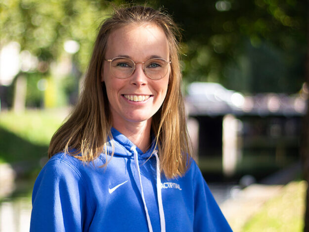 Glimlachende vrouw in blauwe jas buiten