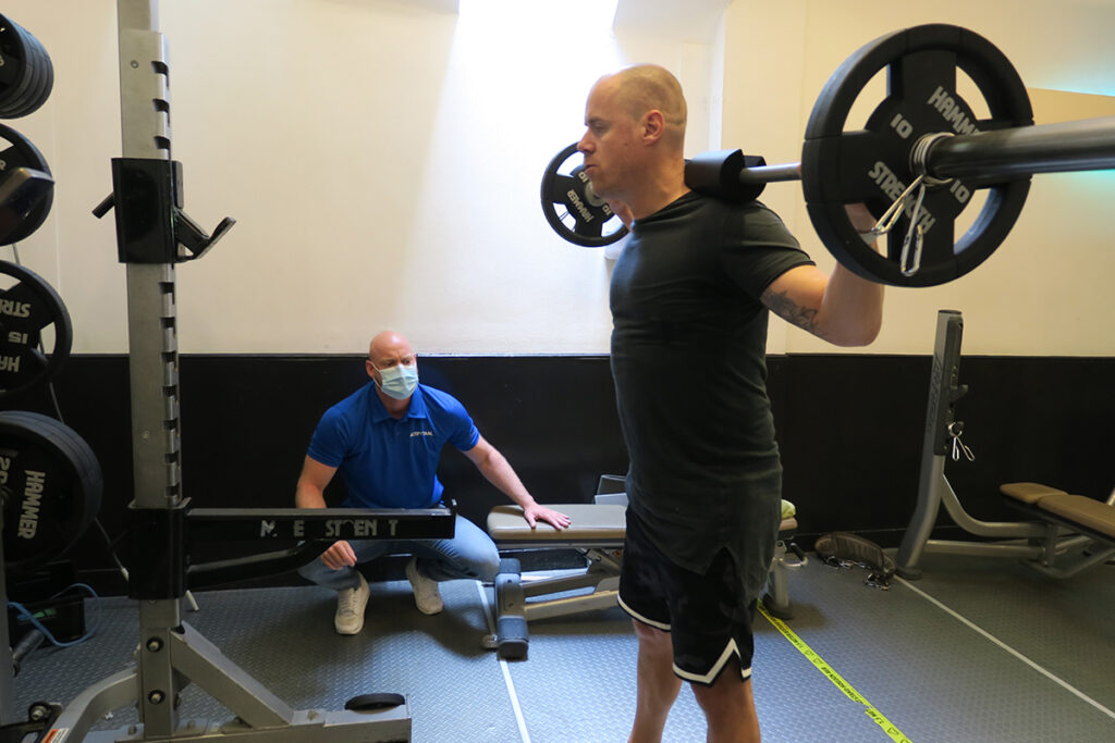 Sportfysiotherapeut helpt een COVID-19 patiënt met revalidatie
