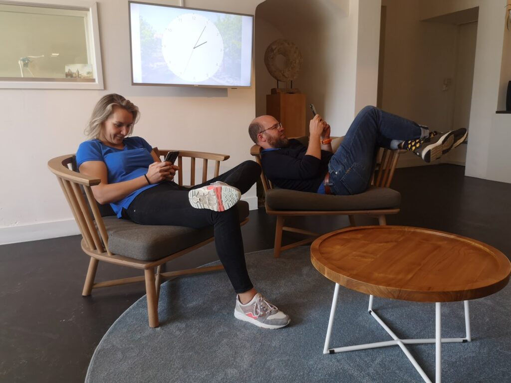 Milennials op zitten op hun smartphone en krijgen nekpijn in Utrecht Centrum