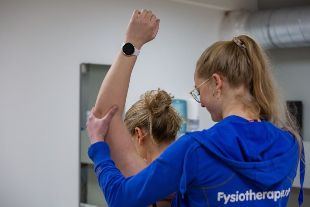 Mevrouw krijgt een behandeling voor een frozen shoulder en schouderklachten.