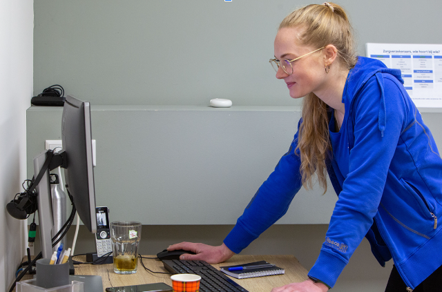 meisje met blauw vest heeft actieve werkhouding op kantoor