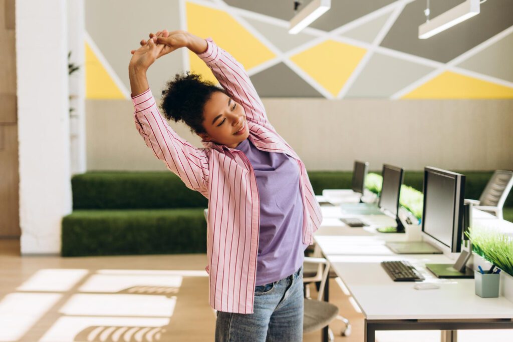 Een vrouw doet oefeningen om nek- en schouderklachten te voorkomen.