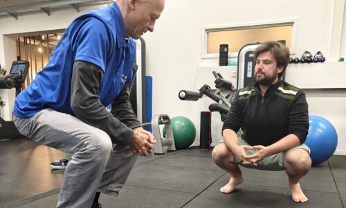Functionele oefentherapie tijdens fysiotherapie in Utrecht bij Actifytaal, waarbij een fysiotherapeut een patiënt begeleidt bij een squat-oefening.