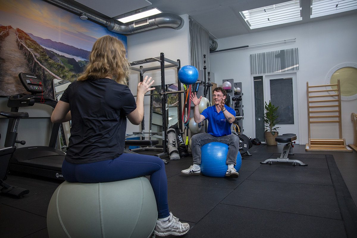 Fysiotherapeut helpt vrouw met bewegen, zodat ze niet te hard van start gaat met sporten en krijgt sportfysiotherapie.