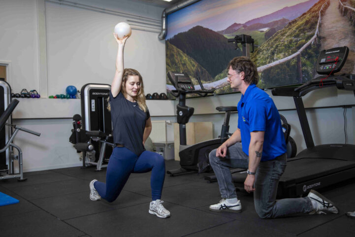 Oefentherapie tijdens fysiotherapie in Utrecht bij Actifytaal, waarbij een patiënt onder begeleiding een lunge-oefening uitvoert in de praktijk.