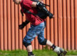 Man in rood t-shirt skeelert met heel veel bescherming aan. Hij doet dit omdat hij last had van blessures door het skeeleren.