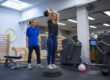 Fysiotherapeut helpt vrouw met bewegen tegen blessures in de sportschool.