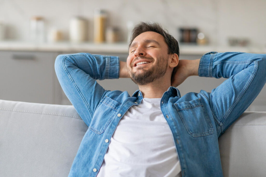 Man zit onderuitgezakt op de bank en moet letten op klachten tijdens ontspanning.